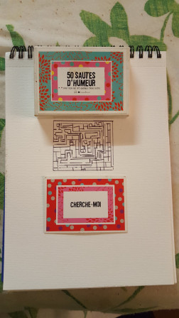 Carton avec cherche moi d'inscrit dessus sur un carnet avec un dessin de labyrinthe
