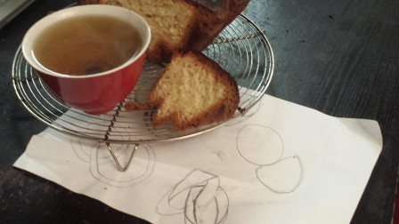 brioche avec une tasse de thé sur un feuille de papier aec des dessins 