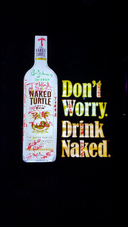 Publicité pour le rhum Naked Turtled avec une bouteille et le texte «Don't Worry. Drink Naked.»